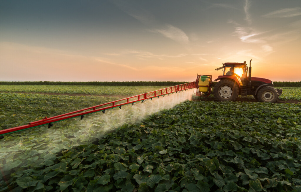 Tractor spraying pesticides on vegetable field with sprayer at spring, precision farming, smart AG, image from Adobe Stock