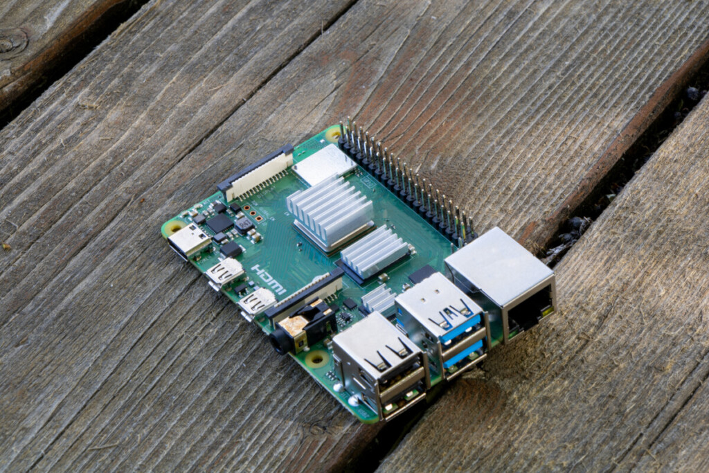 Raspberry PI 4B Microcomputer sitting on wooden table outdoors